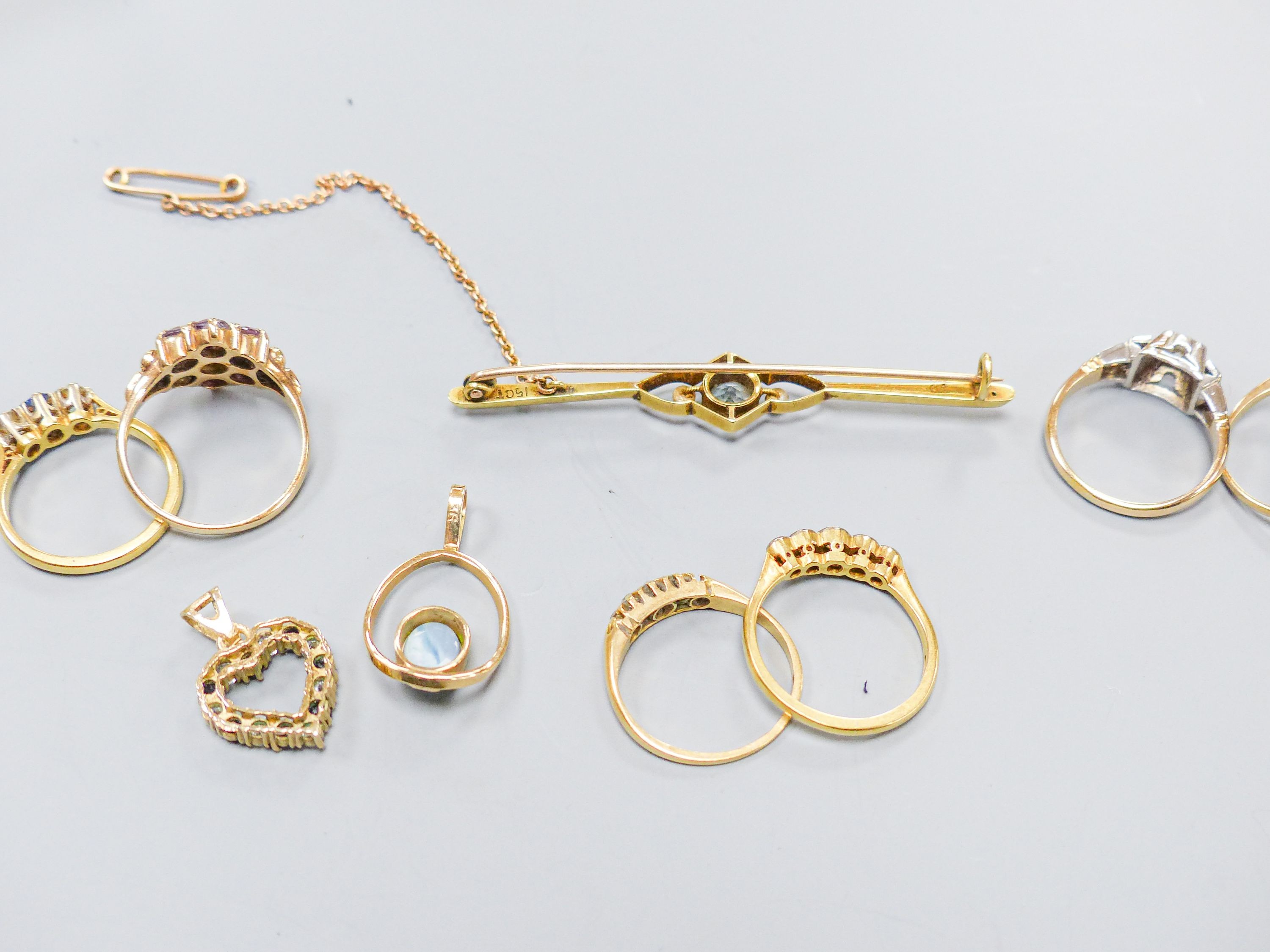 Three 18ct gold and gem set rings including two five stone half hoop(one stone missing) and a sapphire and diamond three stone, gross weight 7.3 grams, four 9ct and gem set rings and a 9ct pendant, gross 11.8 grams, a 15